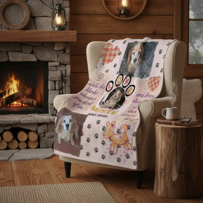 The memorial photo blanket draped over an armchair beside a lit stone fireplace in a cabin