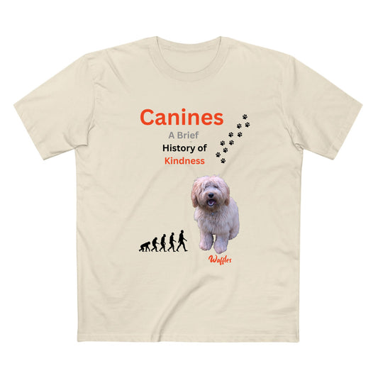 A beige short-sleeve t-shirt with a graphic print on the front. The print features the text 'Canines A Brief History of Kindness' in orange and black, a small black evolution sequence, a photo of a fluffy white dog, black paw prints, and the name 'Waffles' in orange script.